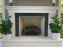 Load image into Gallery viewer, Two fiddle-leaf figs in matte white ceramic pots next to a fireplace.
