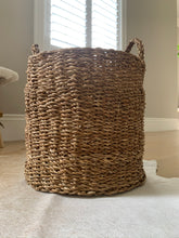 Load image into Gallery viewer, A brown woven basket in front of a window.
