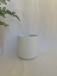 A matte white ceramic pot in front of a white background.
