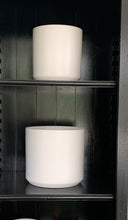 Load image into Gallery viewer, Matte white ceramic pots on black painted shelves.
